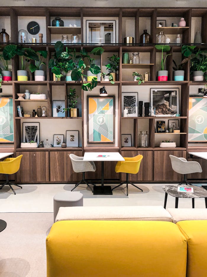 Stylish indoor lounge with wooden shelves, art, and vibrant seating.